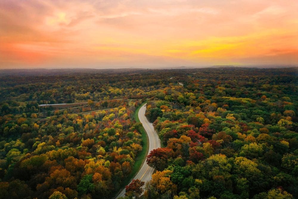 An aerial view of a scenic drive near Galena, Illinois, featuring hues of red, orange, and yellow at sunset.