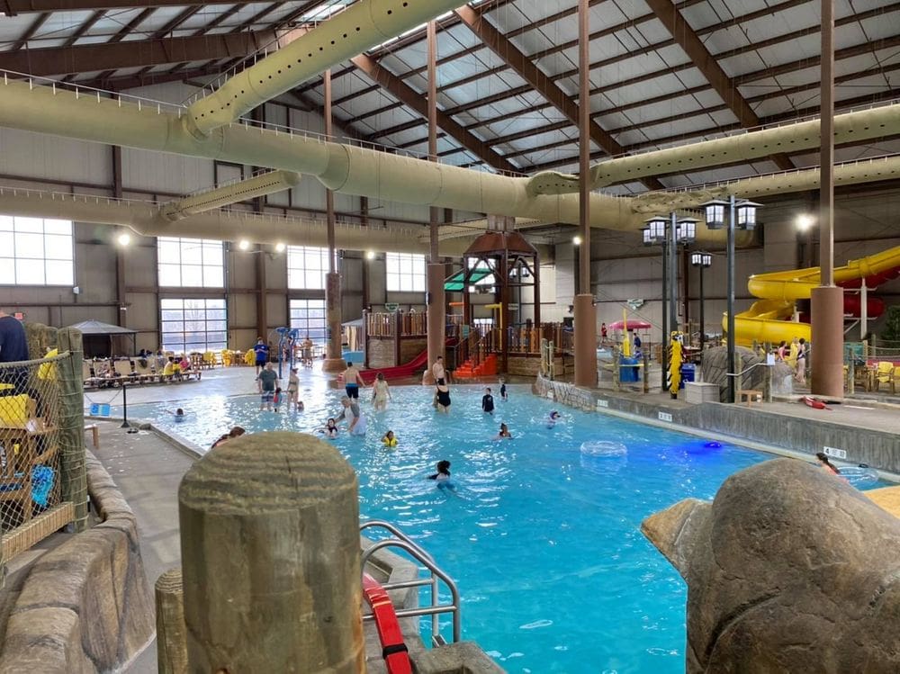 Inside the indoor water park at Greek Peak Mountain Resort, featuring a large pool, slides, and more, making it one of the best water parks in the Northeast for families.