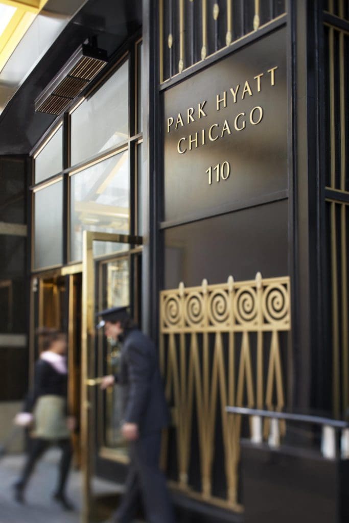 A staff member opens a door for a guest at the Park Hyatt Chicago.