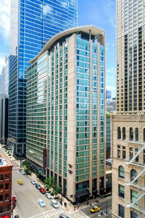 A view of the Residence Inn by Marriott Chicago Downtown / River North, surrounded by nearby buildings on a sunny day.