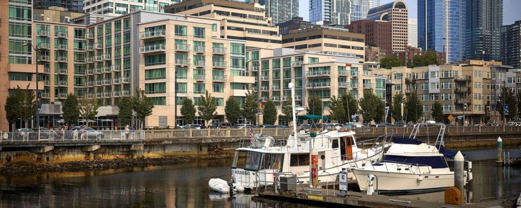 A view of the Seattle Marriott Waterfront behind the water front, which features a few boats.