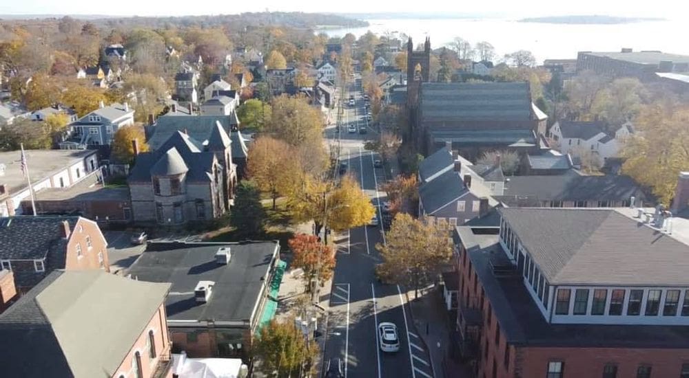An aerial view of Bristol, Rhode Island, featuring fall foliage and historic buildings.