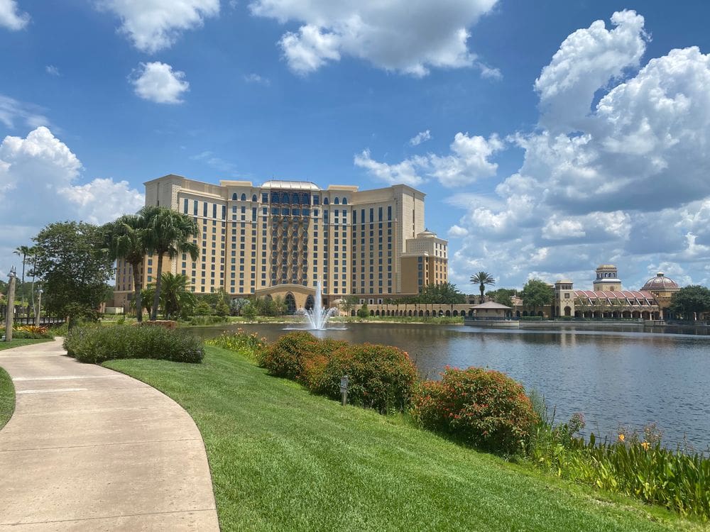 A view of the exterior, pond and fountain, and lush grounds of Disney's Coronado Resort, one of the best Disney moderate resorts for families.