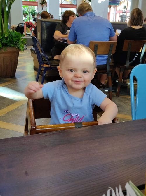 A baby sits in a high chair while enjoying breakfast at Disney's Port Orleans - Riverside Resort, one of the best Disney moderate resorts for families.