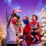 A family of five takes a selfie while celebrating the holidays at Epcot.