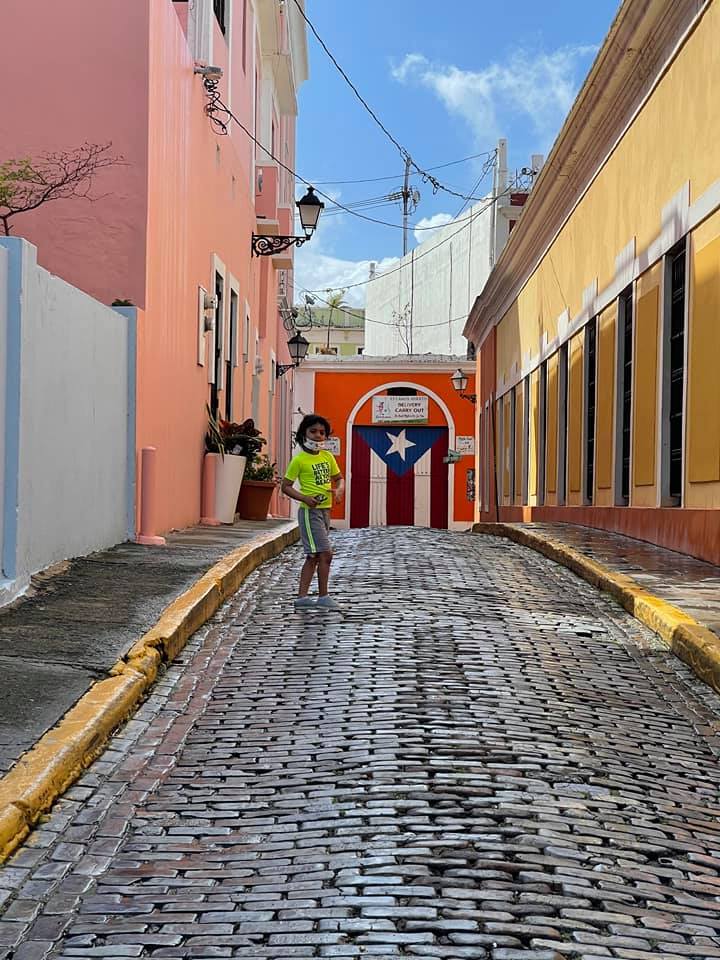 A young boy runs around a cobbled stress within Old San Juan.