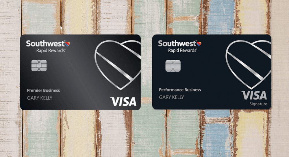 Two Southwest Rapid Rewards cards in black sit side by side on top of a graphic display that looks like weathered wood, business cards available as part of the Southwest companion pass promotion. 
