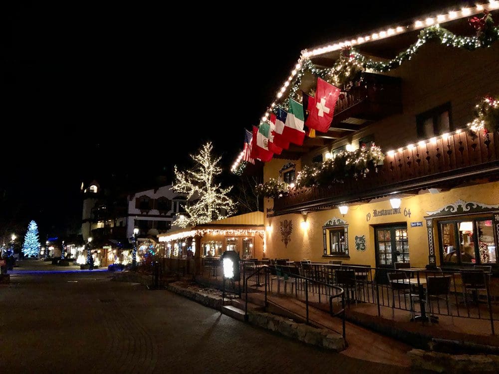 A view down a street in Vail, lit with holiday lights at night.