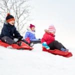3 kids in a sledding hill