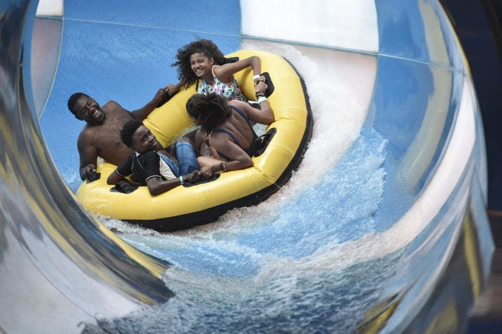 A family of four zooms down a waterslide on a large tube at Photo Courtesy: Great Wolf Lodge Pocono Mountains.