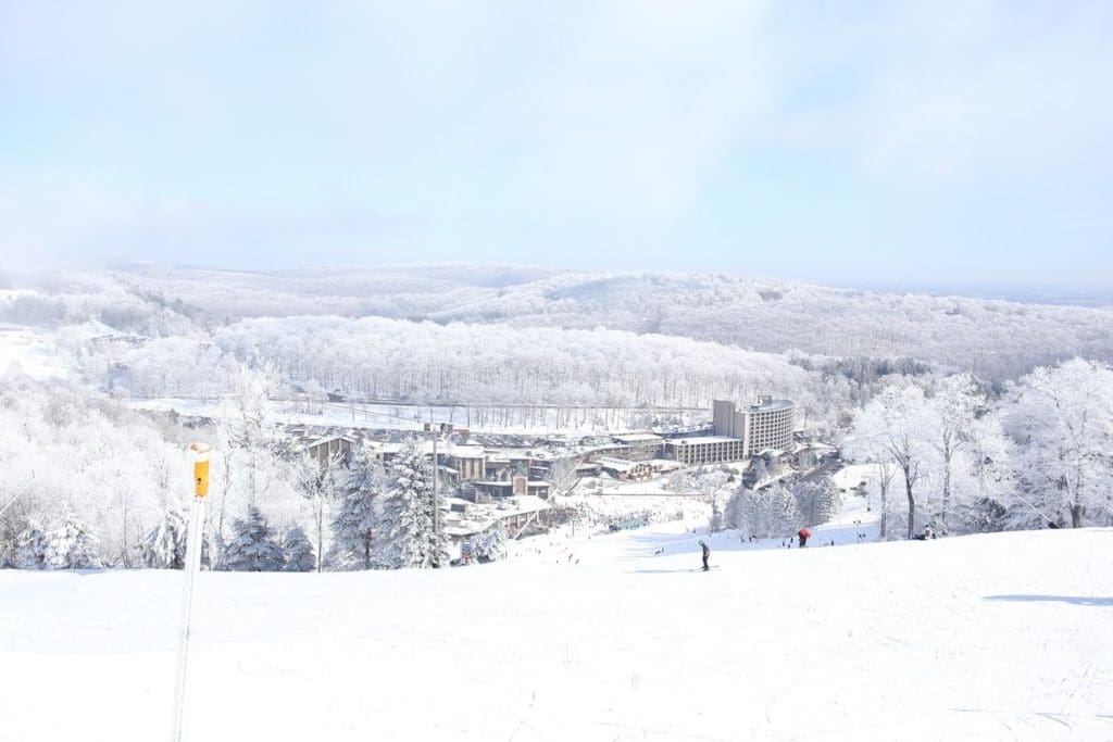 An aerial view of Seven Springs Mountain Resort during the winter, with fresh snow across the grounds.