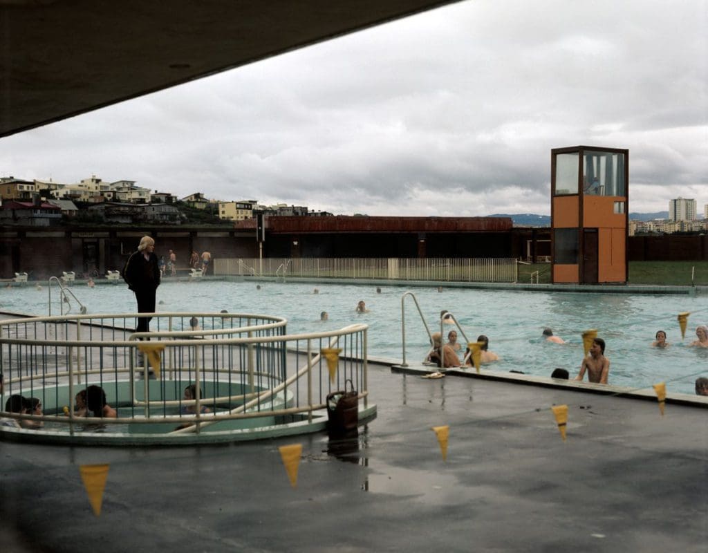 The Laugardalslaug pools in Iceland, where several people are swimming and enjoying the water.
