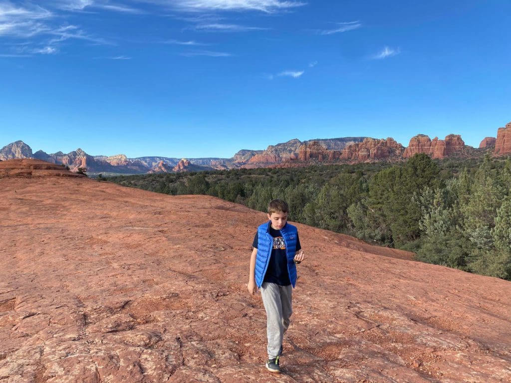 A young boy hikes along a dessert trail, one of the best things to do on this Sedona and Grand Canyon itinerary for families.