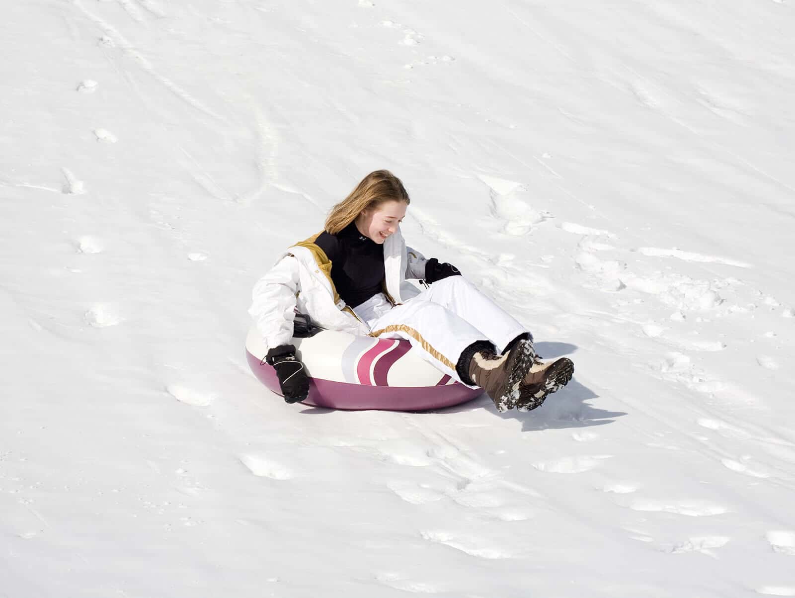 A young girl snow tubes down a snowy hill at Mohonk Mountain House, one of the best all-inclusive hotels in the United States for families.