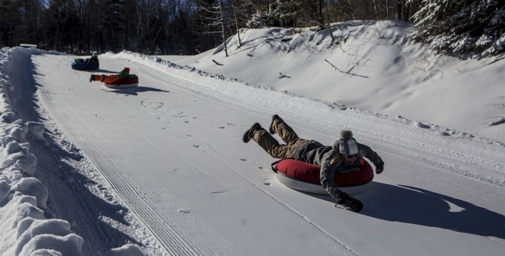 Three snow tubers race down the snowy track at Mt Pisgah.