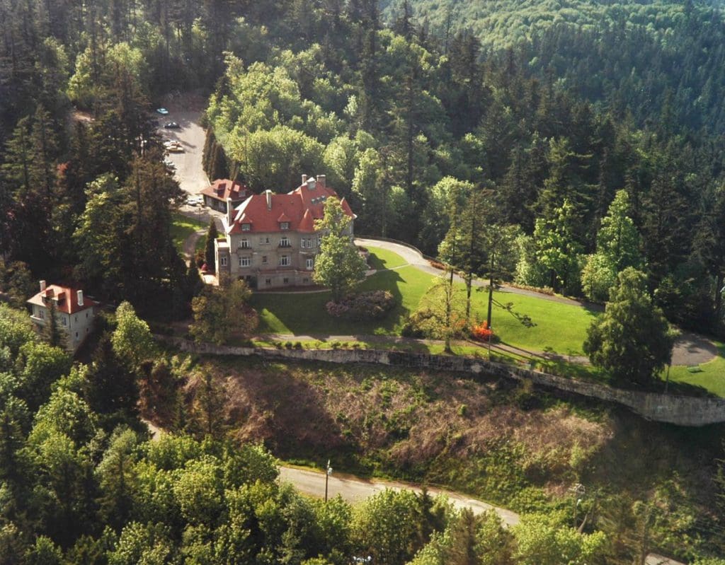 An aerial view of the Pittock Mansion, featuring a large home and expansive grounds.