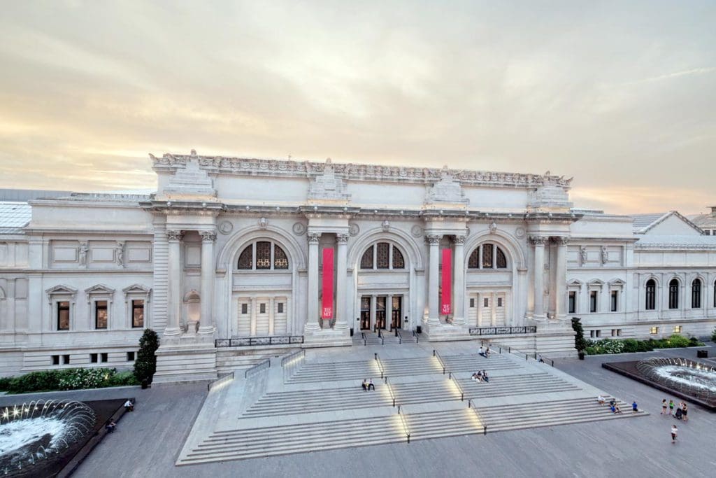 The grand entrance to the Metropolitan Museum of Art, featuring beautiful stairs and columns near sunset.