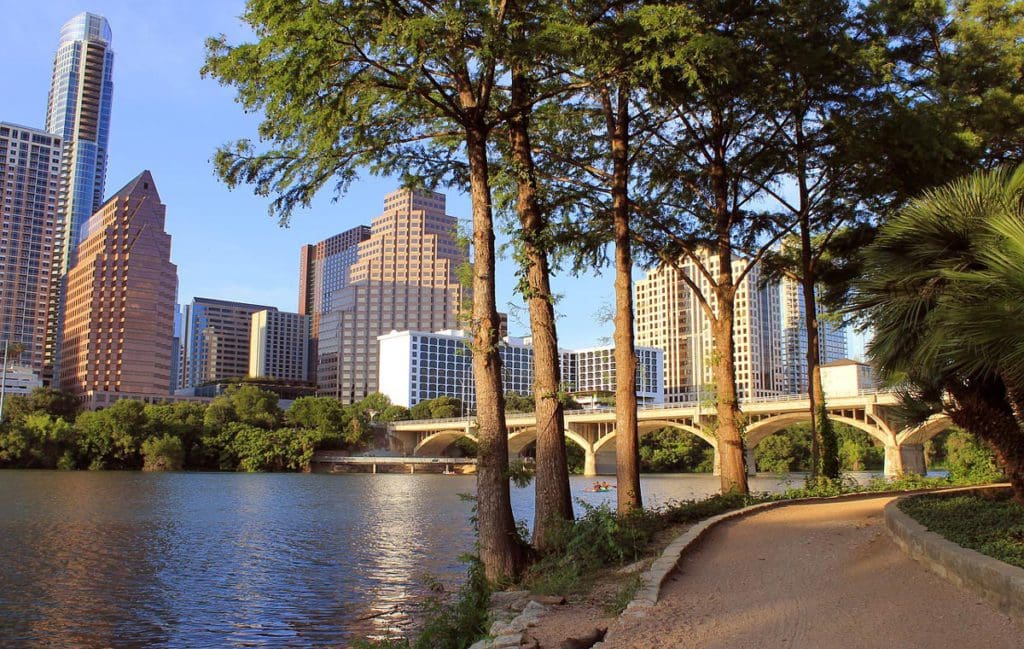 A view of a river running through Austin, with the downtown skyline in the distance.