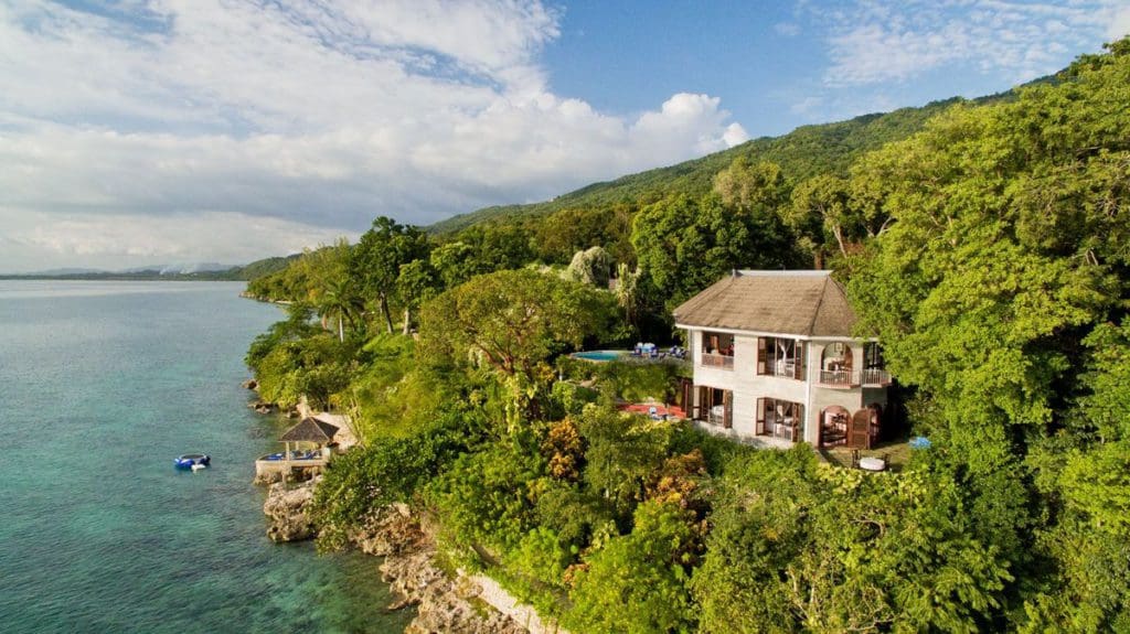 An aerial view of the Bluefields Bay Villas Jamaica, located in lush foliage along the beach.