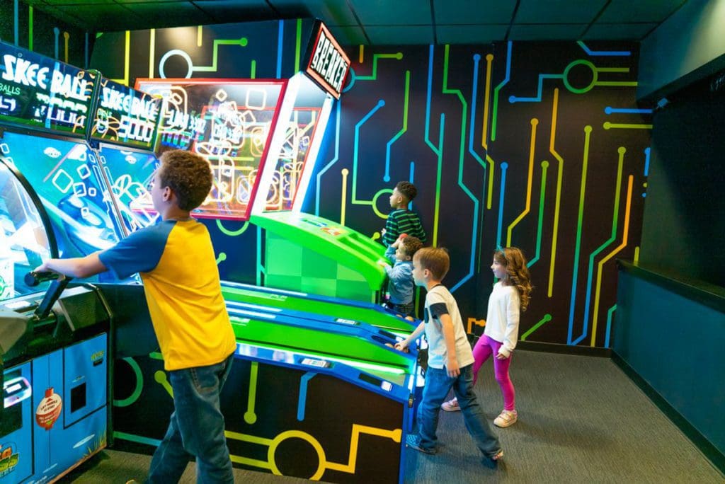 Several kids play games at the arcade on-sight at the Cartoon Network Hotel.