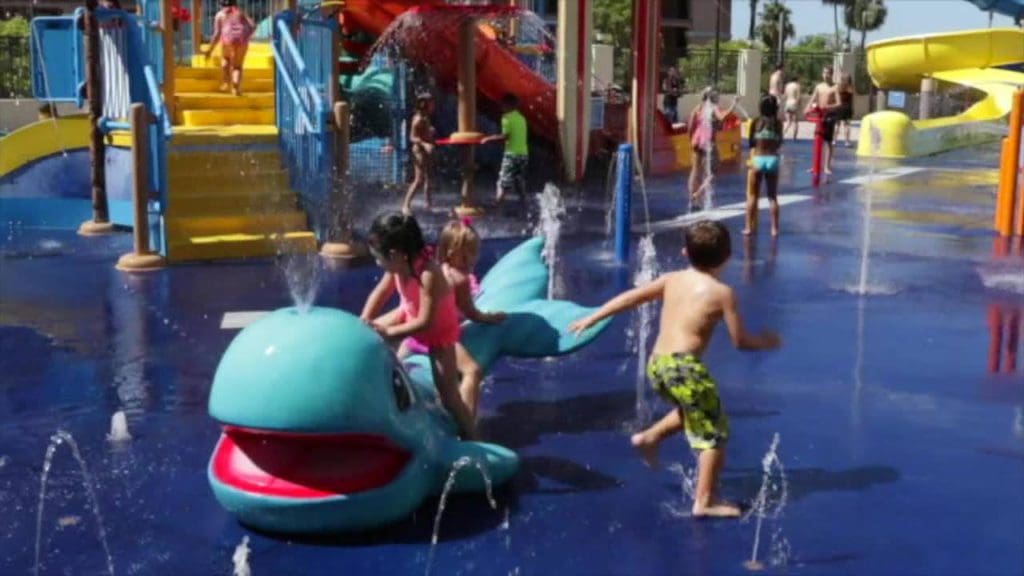 Two kids splash and play at the splash pad at Courtyard by Marriott Anaheim Theme Park Entrance.