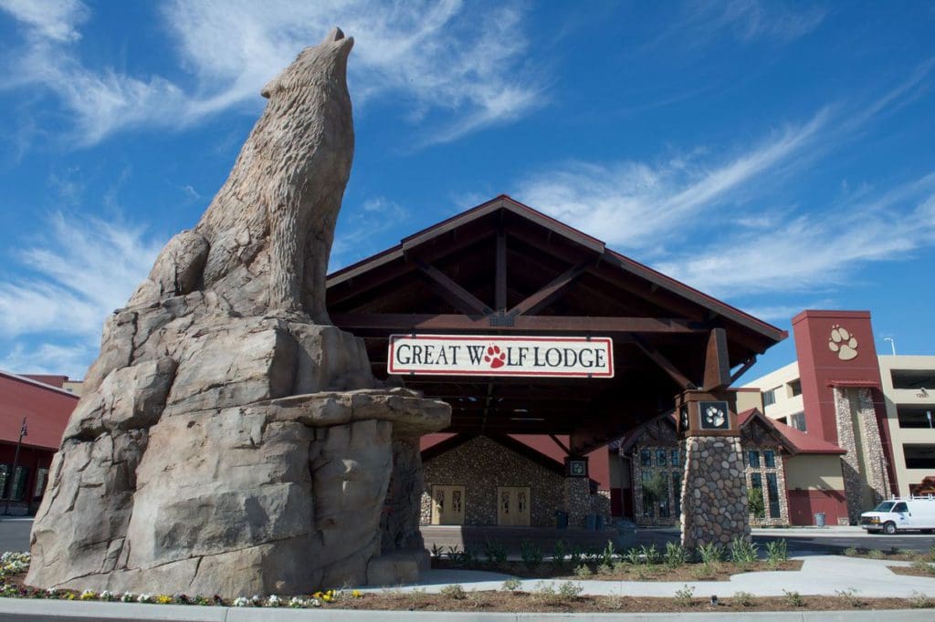 The exterior to Great Wolf Lodge Southern California, featuring a cabin-vibe and large howling wolf statue.