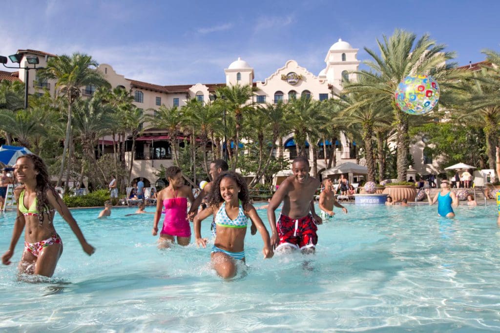 Several people wade through the water in a pool at the Hard Rock Hotel at Universal Orlando.
