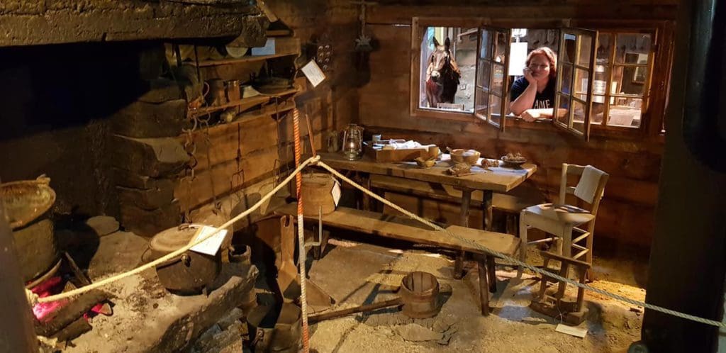 Inside a exhibit of an old ski house at Matterhorn Museum, featuring old tools, dishes, and other items.