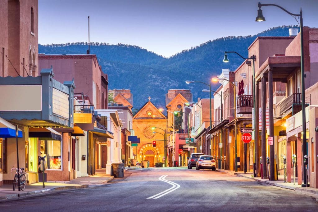 The main street in Santa Fe, leading to a Spanish-style church, and mountains in the distance, one of the best Moms’ Getaways or Girls’ Trip Ideas.
