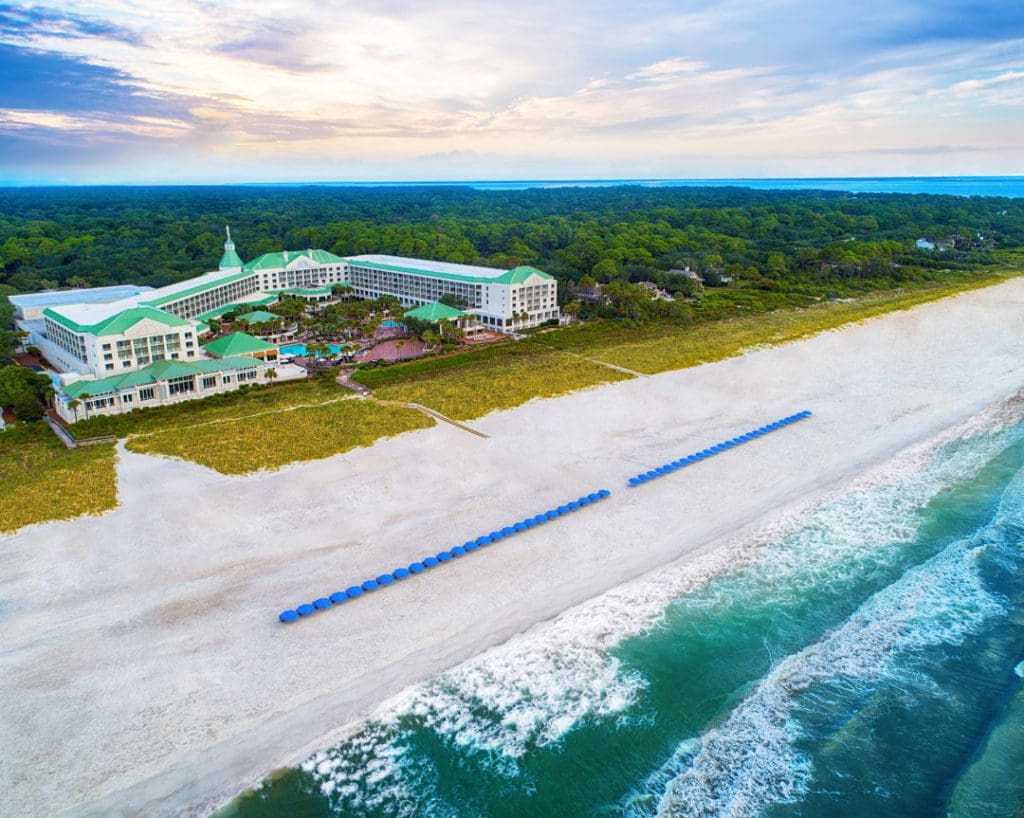 An aerial view of the Photo Courtesy: Marriott Hotels & Resorts, featuring a long stretch of beach and beach loungers.