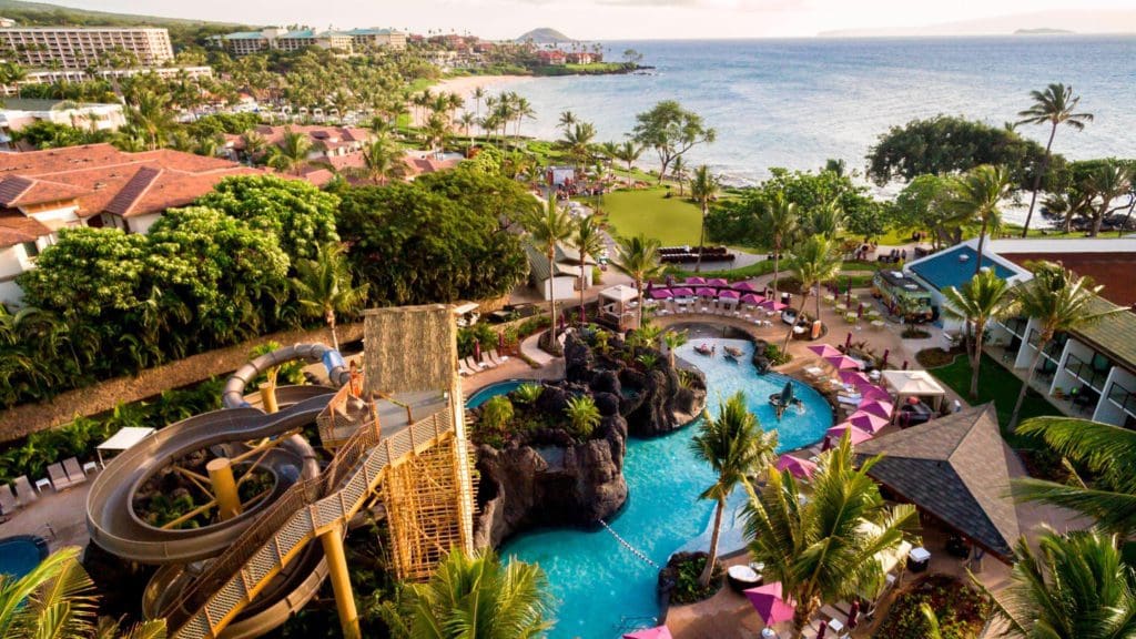 An aerial view of the pool and surrounding pool deck at Wailea Beach Resort, with the ocean in the distance.