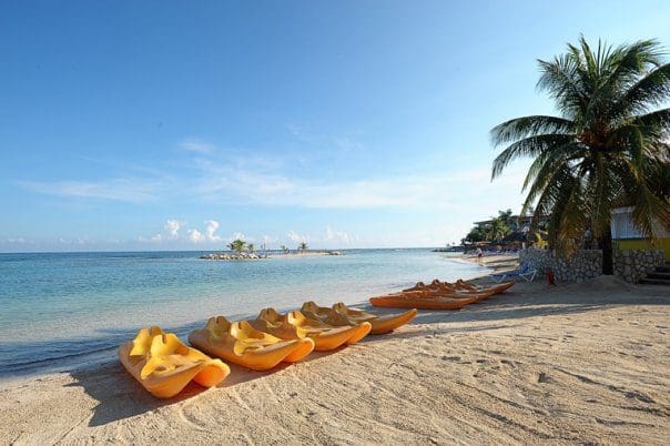 Several yellow sea kayaks rest along the beach at Holiday Inn Montego Bay.