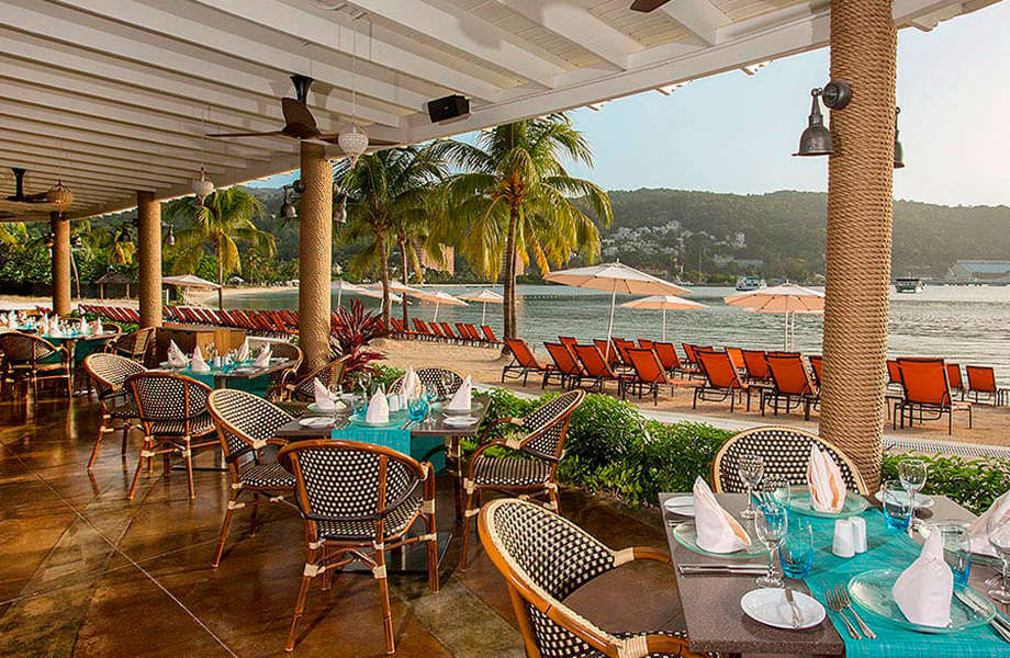 The tropical, open-air dining room at the Moon Palace Jamaica, featuring an ocean view.