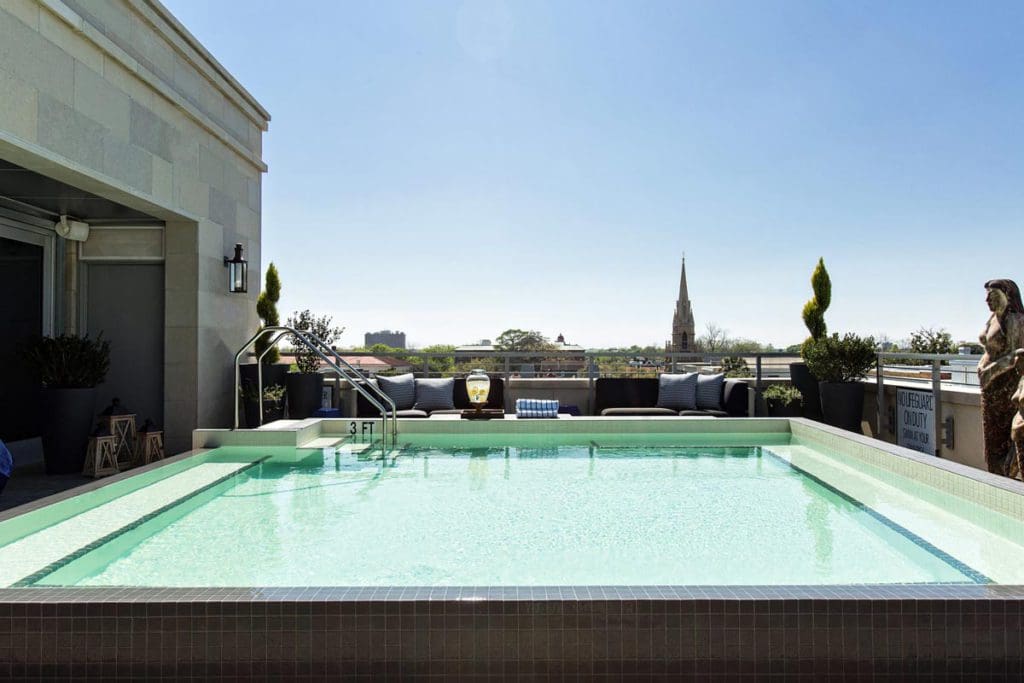 The rooftop pool at The Restoration Charleston, flanked on one side by plush furniture.