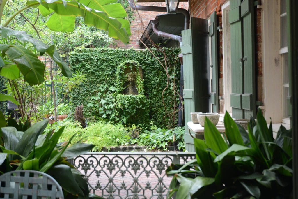 The interior courtyard at Soniat House Hotel, featuring lush flowers and southern-style architecture. 