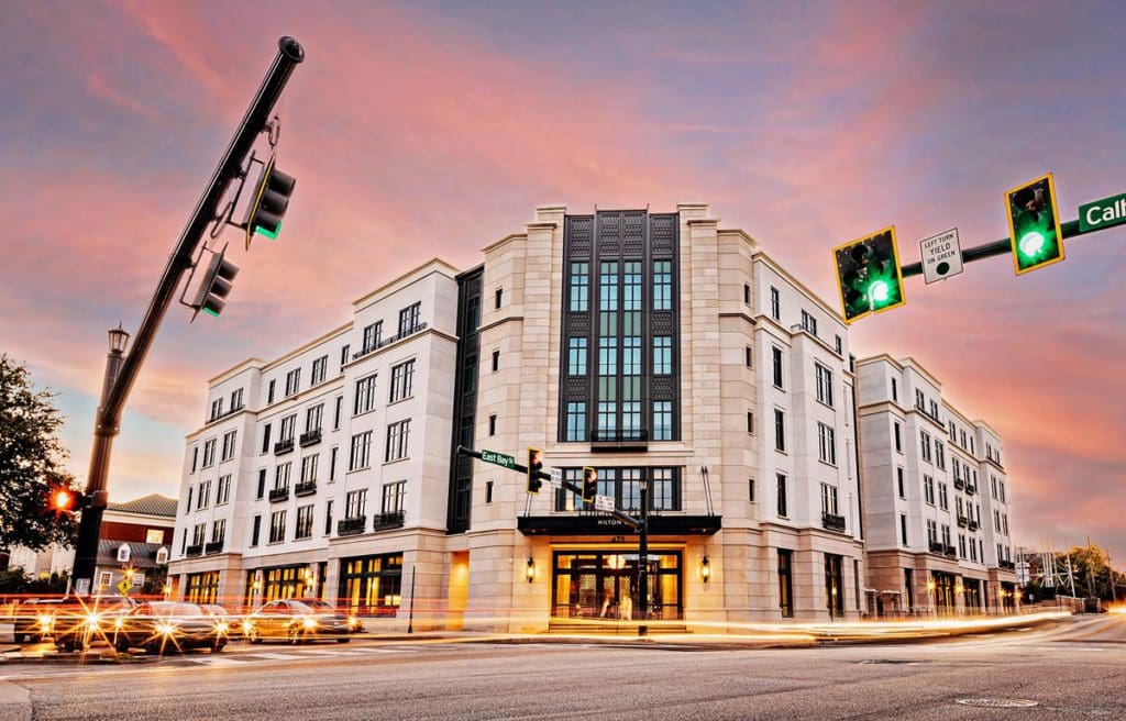 Liberty Place Charleston by Hilton Club, situated on the corner of a large street in Charleston at sunset.