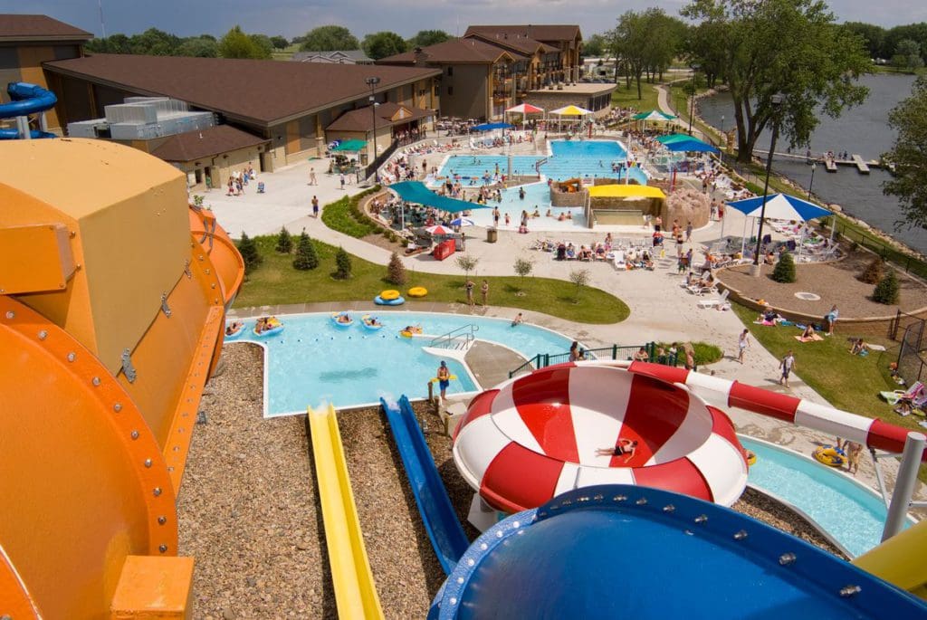 The large outdoor water park at King's Pointe Resort, with resort building behind the pools.