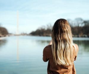 A woman looks down the Washington Mall at the Washington Monument in DC.