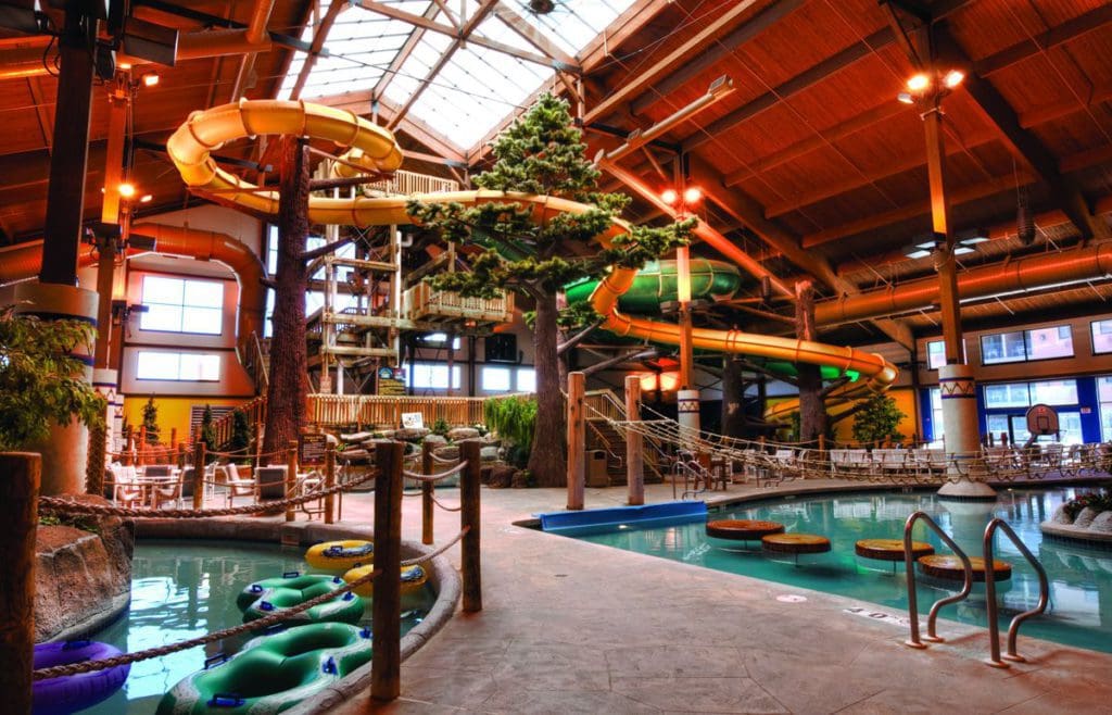 The indoor slides and water park of Timber Ridge Lodge & Waterpark, featuring a windowed ceiling and many water entry points.