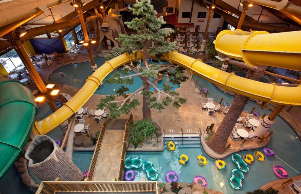 An aerial view of the indoor water park at Timber Ridge Lodge & Waterpark, featuring many colorful slides and a lazy river.