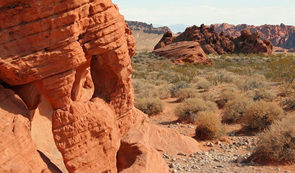 A close up of red rock at ,Valley of Fire State Park, with a desert scene expanding into the distance.