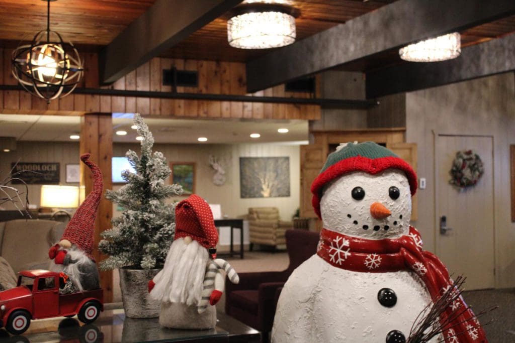 The lobby of Woodloch Resort, decorated for winter with snowman and snow-dusted evergreen trees.
