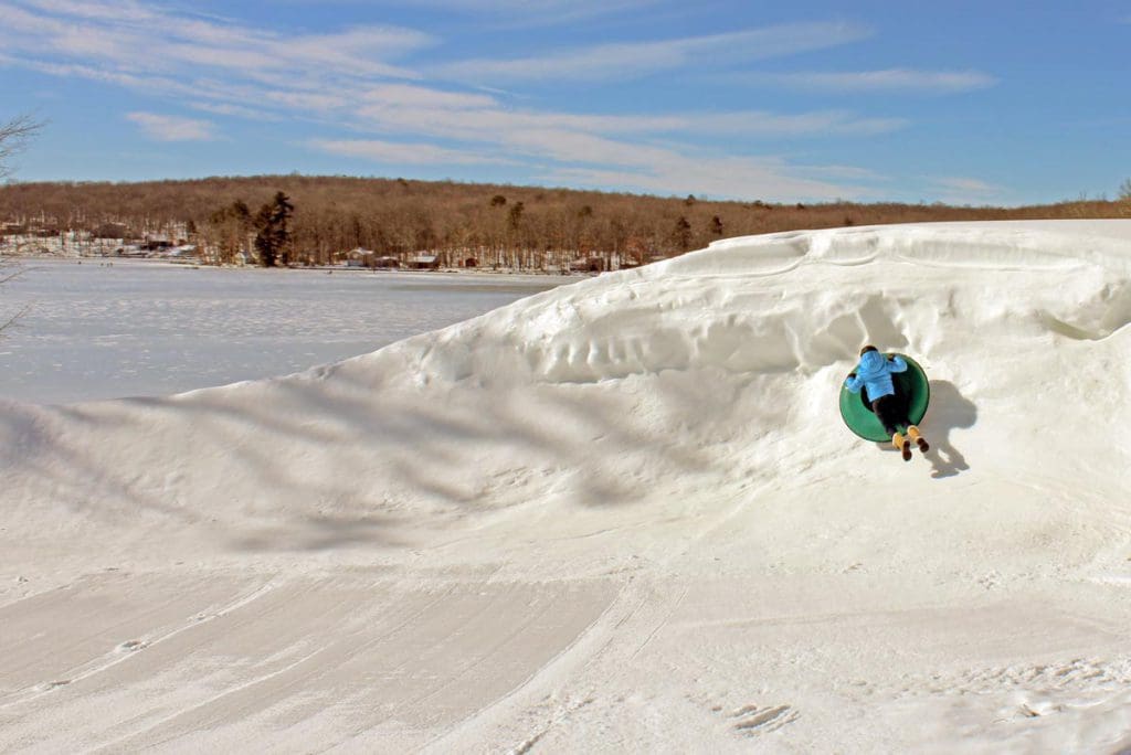A young boy flies on a snow tube around the valley of snow at Woodloch Resort.