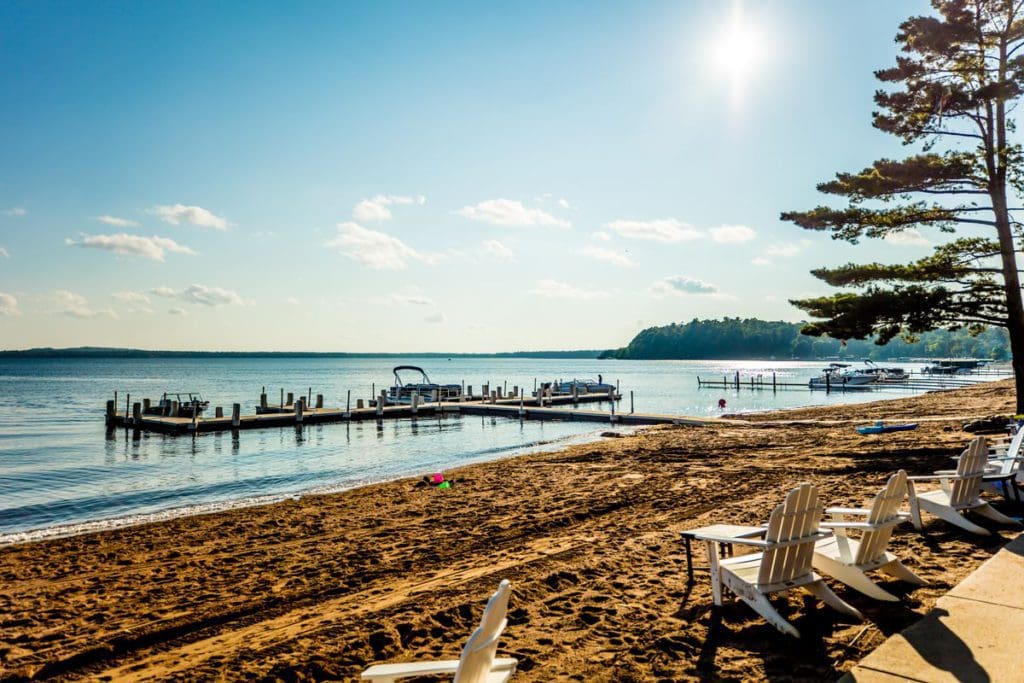 A stunning lake shoreline in Minnesota, featuring large docks and a sandy beach.