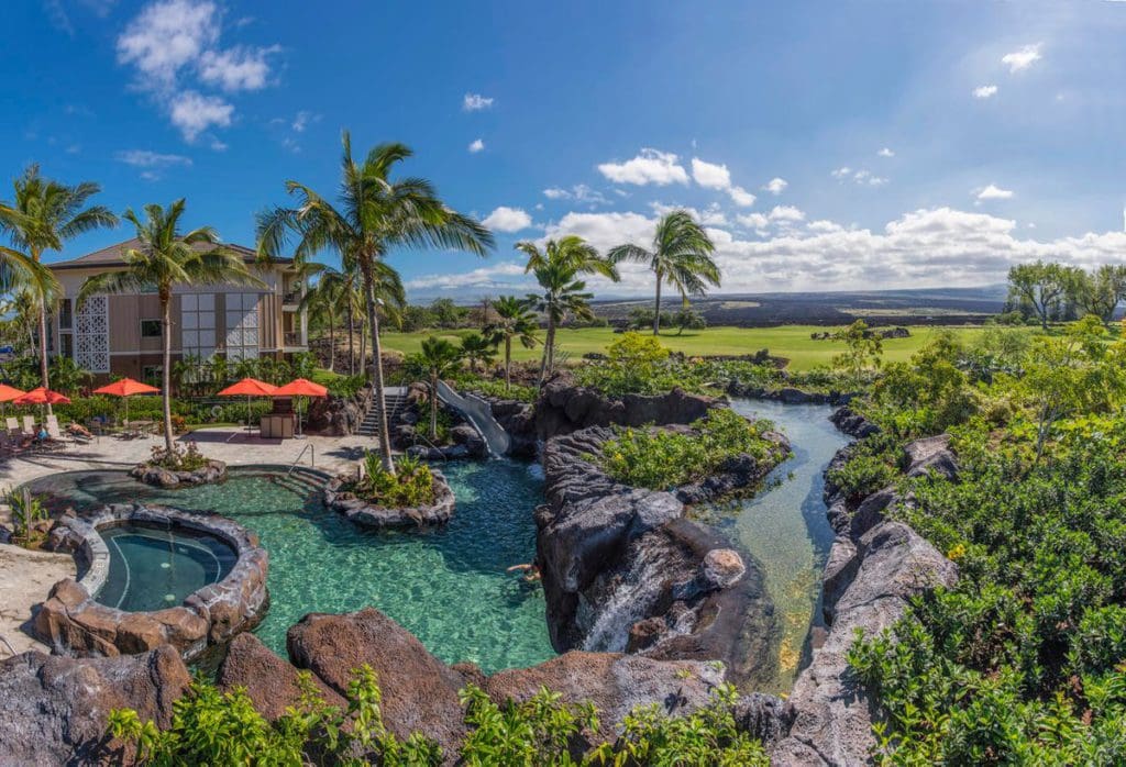 An aerial view of Hilton Grand Vacations Club Kings’ Land Waikoloa, featuring its large pool and lush resort grounds.