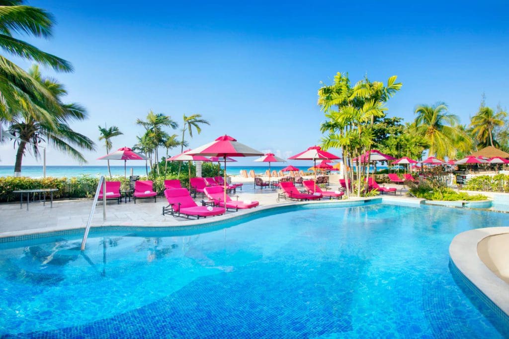 Several hot pink poolside loungers sit along the pool at O2 Beach Club and Spa.