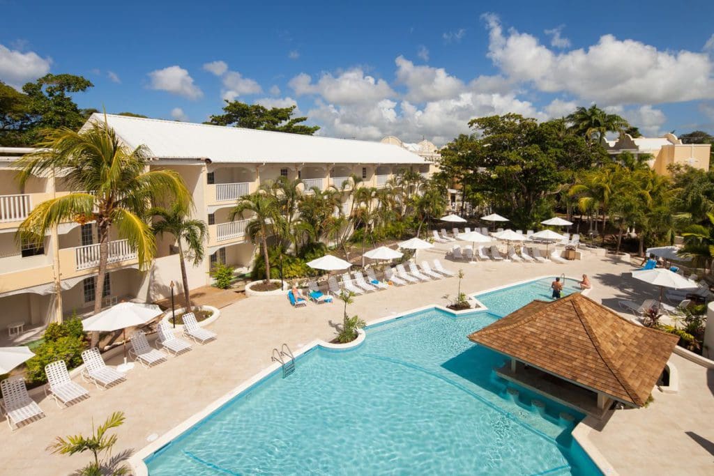 An aerial view of the pool and resort buildings on a sunny day at Sugar Bay Barbados.