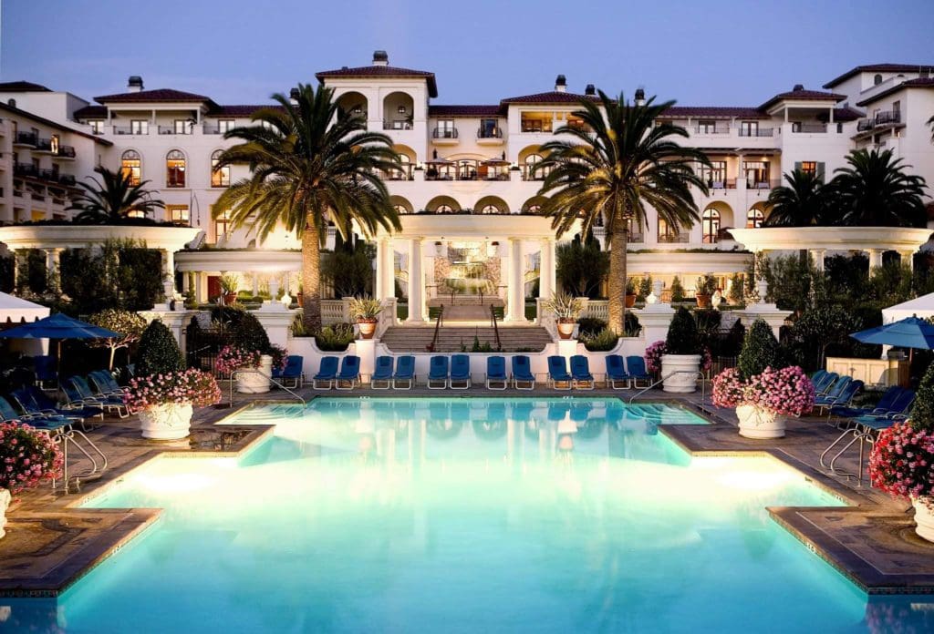 The pool lit up at night, in the center of the resort buildings for Waldorf Astoria Monarch Beach Resort & Club, one of the best Hilton Hotels in the United States for families.