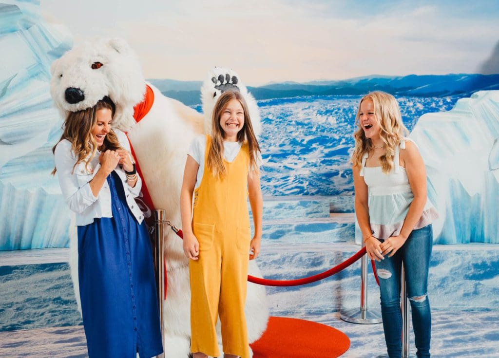 Kids laugh and look on as their mom pretends to be eaten by Coca-Cola's iconic polar bear at World of Coca-Cola.