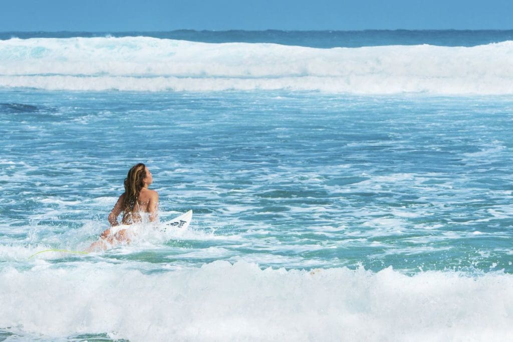 A woman surfs along the waves off-shore from Barbados.